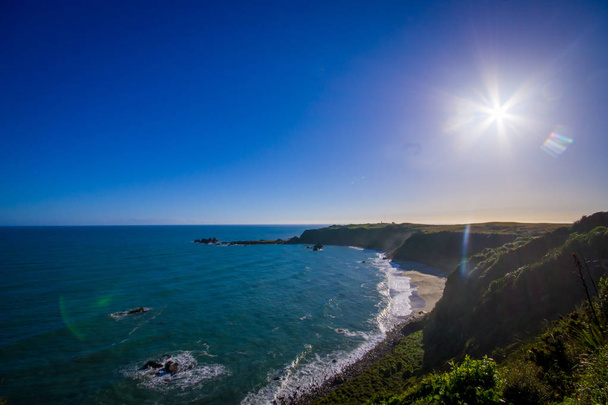 Sun shine over a Island near Cape Foulwind, View from the Cape Foulwind walkway at the Seal Colony, Tauranga Bay. New Zealand - Fotografie, Obrázek