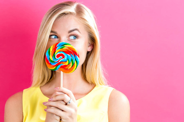 Young woman holding a lollipop - Zdjęcie, obraz