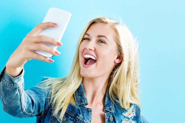 Young woman taking a selfie - Valokuva, kuva