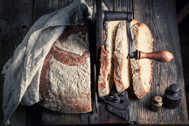 Homemade loaf of bread on old wooden table - Φωτογραφία, εικόνα