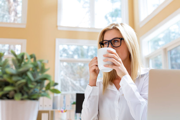 Happy young woman drinking coffee - Фото, изображение