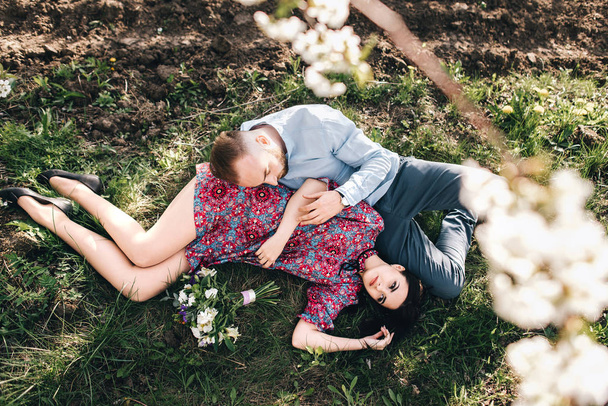 Young couple in the blooming garden - Фото, изображение