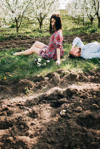 Молодая пара в цветущем саду
 - Фото, изображение