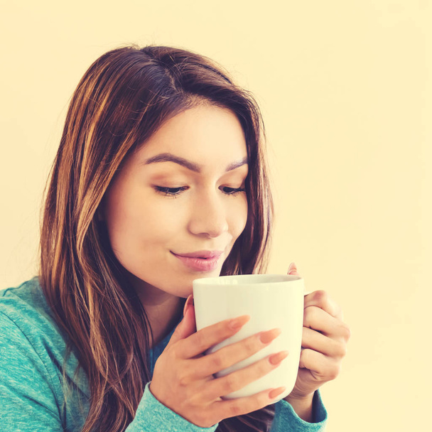 Nuori latino nainen juo kahvia
 - Valokuva, kuva