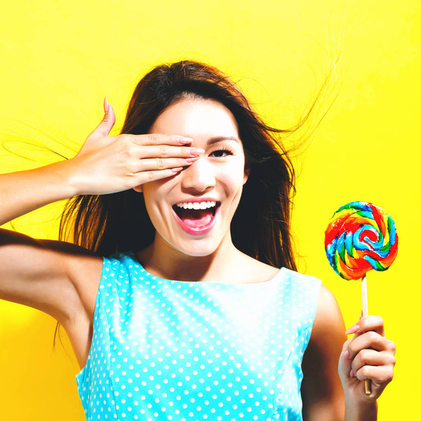 Young woman holding a lollipop - Fotó, kép
