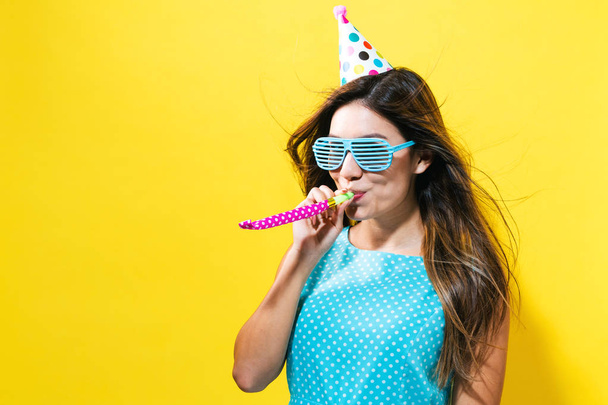 Young woman with party hat with noisemaker - Фото, зображення