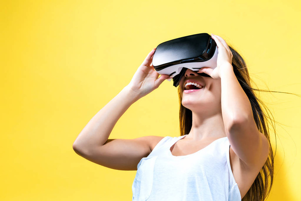 Young woman using virtual reality headset - 写真・画像