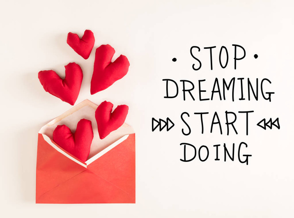 Stop Dreaming Start Doing message with red heart cushions - Фото, изображение