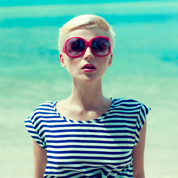 Fashion portrait of a girl on a background of the sea - Foto, afbeelding