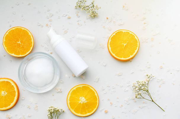 Kosmetikschaum-Pumpe Flaschenbehälter mit frischen Orangenscheiben, leeres Etikett für Branding-Mock-Up, natürliches Vitamin-C-Beauty-Produktkonzept. - Foto, Bild
