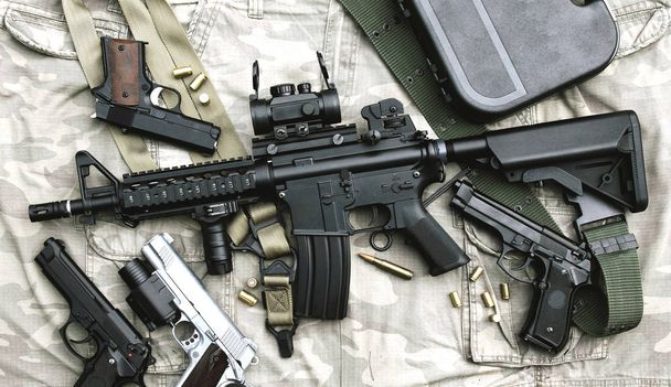 Wapens en militaire uitrusting voor het leger, Assault rifle, gun (M4a1) en pistool op camouflage achtergrond. - Foto, afbeelding
