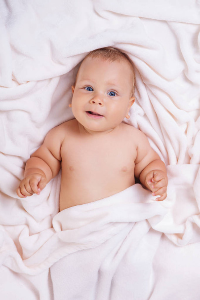 Cute smiling baby under towel after bath - Foto, Bild
