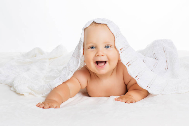 Cute smiling baby under towel after bath - Foto, imagen