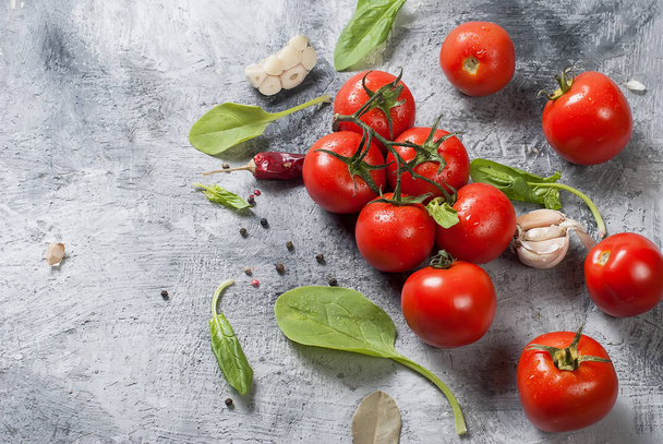 cherry tomatoes on a branch, spinach leaves and spice - Foto, imagen