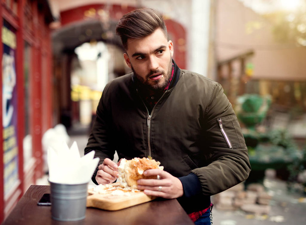 Nuori mies syö hampurilaisia
 - Valokuva, kuva