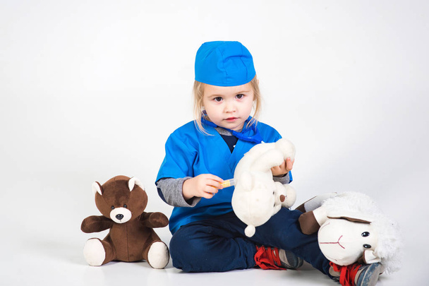 doctor kid in uniform playing vet with toy animal - 写真・画像