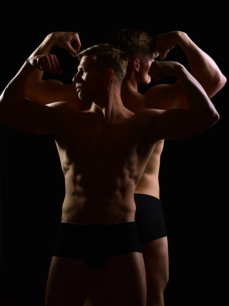 мускулистые мужчины-близнецы с обнаженным туловищем, шесть упаковок в нижнем белье
 - Фото, изображение