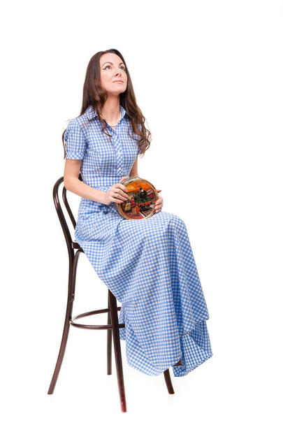 Krásná dívka sedí na židli s bonboniéra v ruce aga - Fotografie, Obrázek