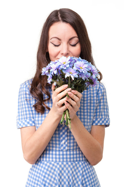 schöne Mädchen in einem Kleid in einem blauen Käfig mit Blumen Chrysanthe - Foto, Bild