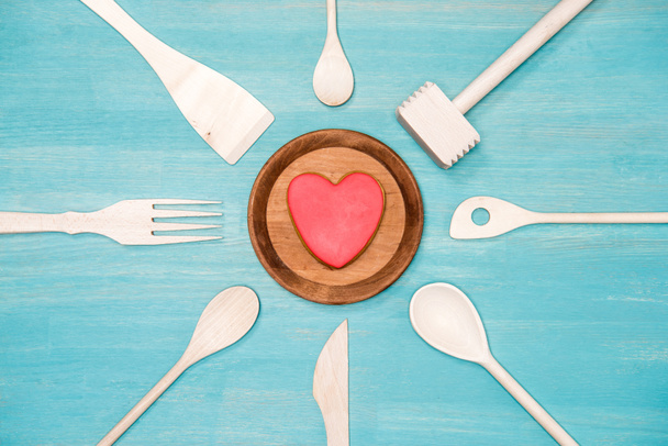 kalp simgesi olan çeşitli Ahşap mutfak aletleri üstten görünüm plaka üzerinde - Fotoğraf, Görsel