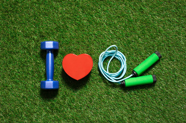 mancuerna colorida con símbolo del corazón y saltar la cuerda en la hierba
 - Foto, Imagen