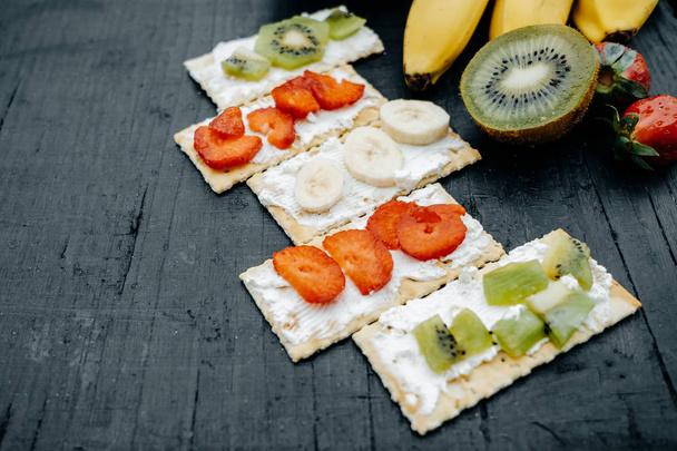 Snacks on a handmade Crackers with cheese and fruits: bananas, s - Fotoğraf, Görsel
