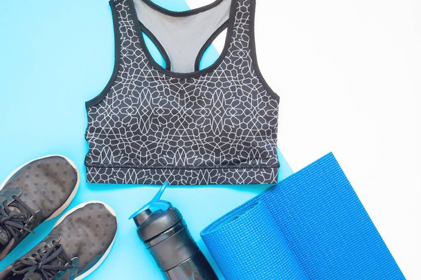 Pose plate d'équipements de sport avec des vêtements de sport en bleu et noir thème de couleur
 - Photo, image