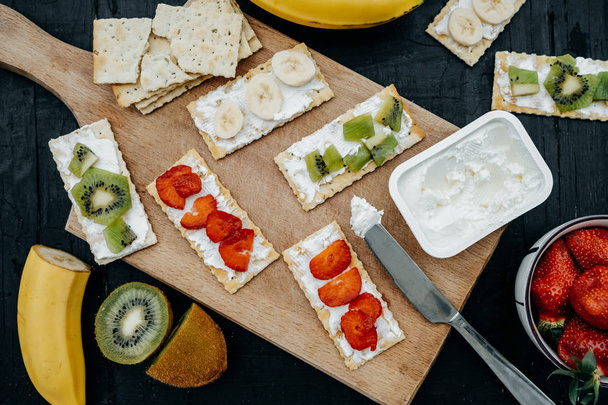 Close up of a variety of crackers with cheese and fruits: banana - Photo, Image