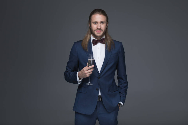 Mann im Smoking hält Glas mit Champagner - Foto, Bild