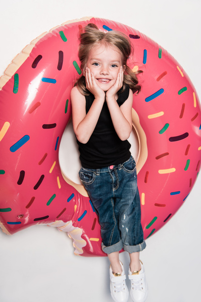 malá holčička s úsměvem vleže na trubice - Fotografie, Obrázek