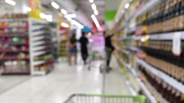Homályos lövés a fogyasztók szupermarketben a bevásárlókosár  - Felvétel, videó