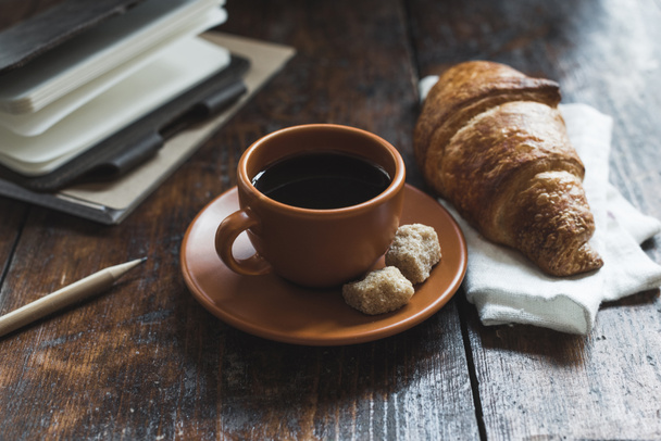 kávé és croissant-t és jegyzetfüzet ceruzával asztallapra - Fotó, kép