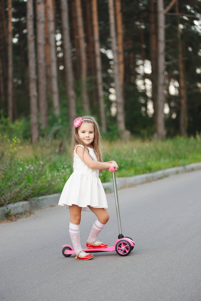 beautiful girl with scooter on the road - Foto, Imagen