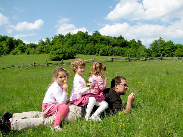 Pai com filhas no campo
 - Foto, Imagem