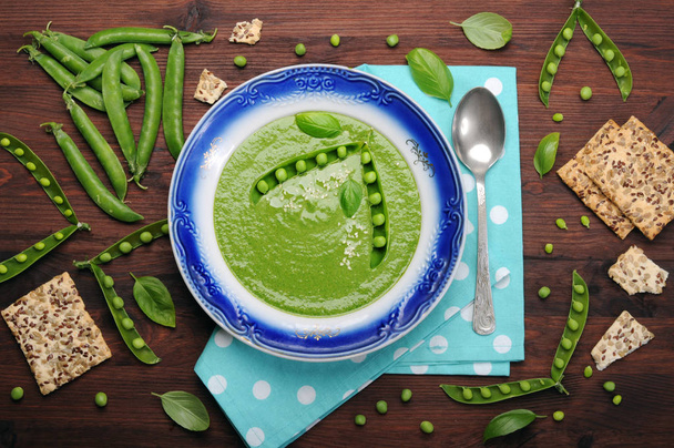 Light dietary cream soup from vegetables (potatoes, carrots, spinach and green peas) on a dark wooden surface. Low-calorie product for weight loss. Vegetarian, vegan concept. Organic food - Fotoğraf, Görsel