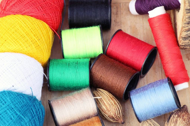 Colorful thread for sewing on wood background - Photo, Image