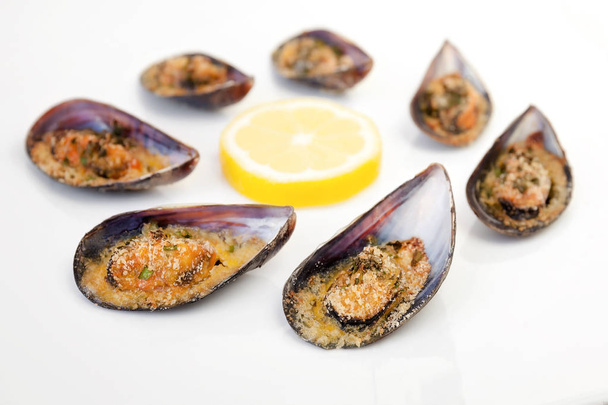 Gratin mussels. Grilled mussels cooked in the oven, grated pan and parsley. - Photo, Image