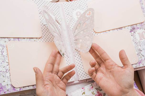 Дівчина тримає в руках ремесла, скрапбукінг для весілля або інше
 - Фото, зображення