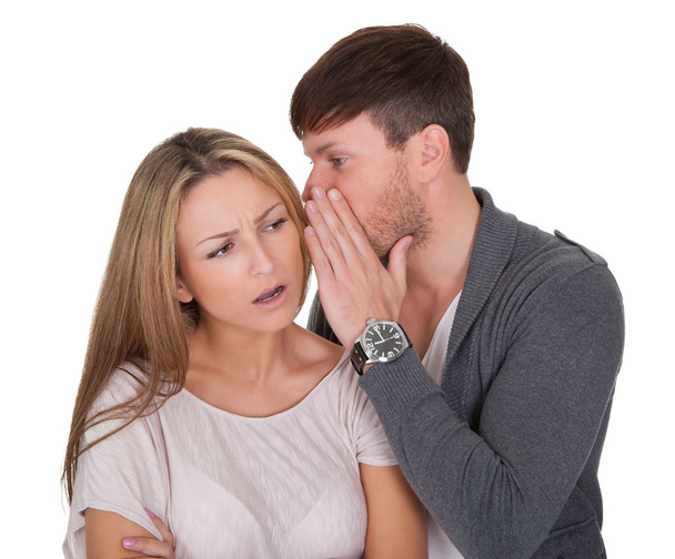 Man whispering in a woman's ear - 写真・画像