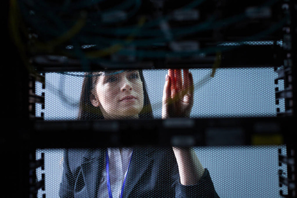 Serious attractive woman looking at the data server - Photo, Image