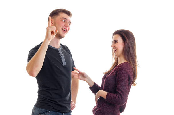 joyful young man stands with his cheerful girl and raises a finger up - Фото, изображение
