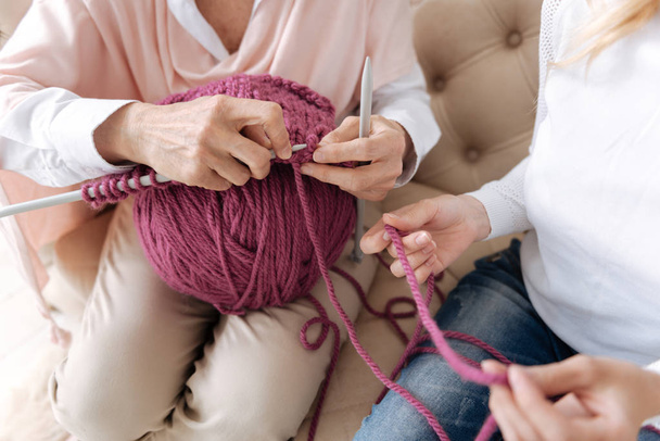Two pairs of female hands doing knitwork - Foto, afbeelding