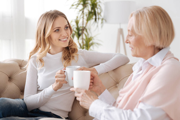 Mother and daughter chatting over a cup of tea - Photo, image