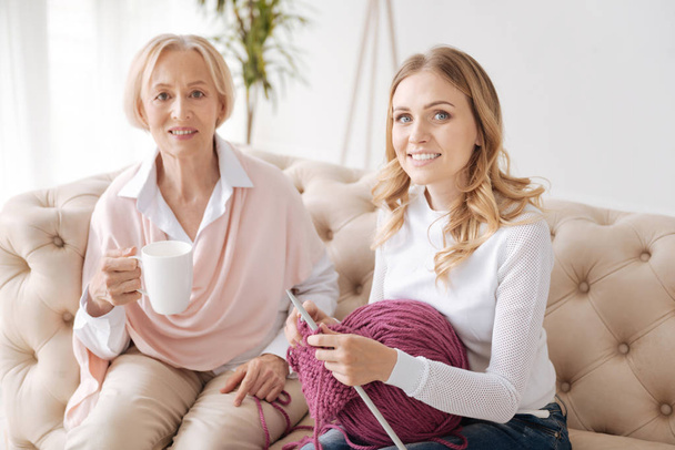 Adult daughter and her mother sitting on the sofa together - Foto, immagini