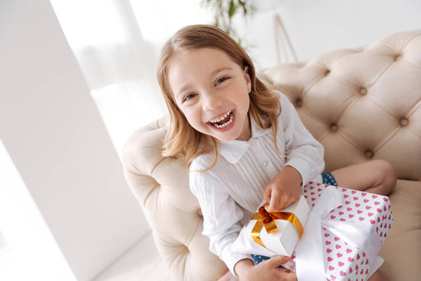Overjoyed little girl holding a pile of presents - Фото, зображення