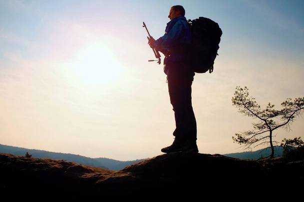 Alleen volwassen man backpacker bij zonsopgang op open uitzicht op de bergtop - Foto, afbeelding