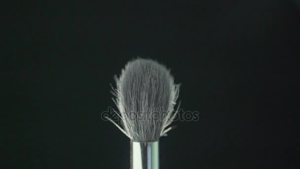 brush for powder on a black background with dust from powder. - Imágenes, Vídeo