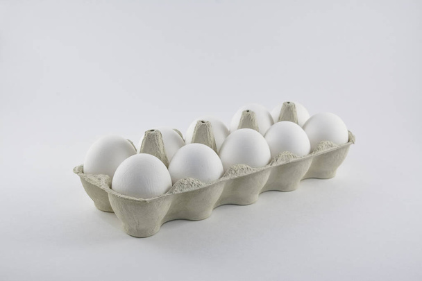 Dozen white chicken eggs in a cardboard box. - Фото, изображение