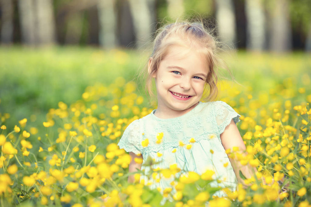Happy little girl on blooming meadow - Foto, Bild