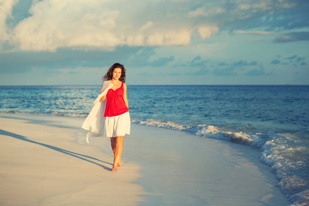 Young woman walking on the beach - Foto, imagen
